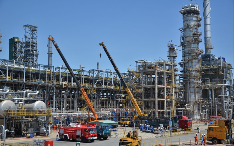 Steel structure installation at a construction site, with structural steel columns and beams being aligned during assembly.